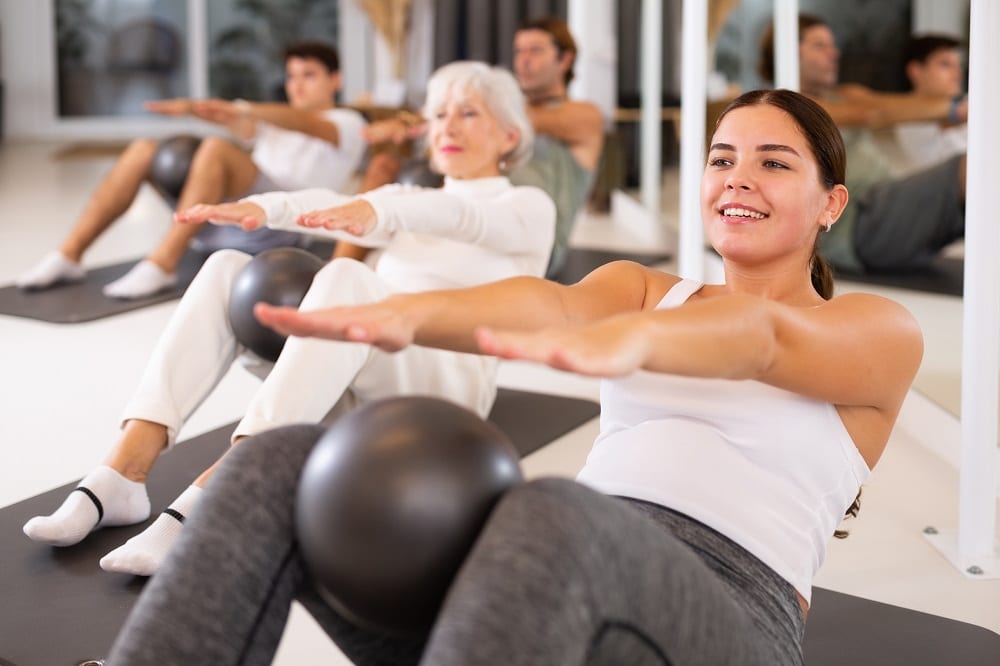 Adult,People,Different,Ages,Practicing,Pilates,With,Ball,At,Group